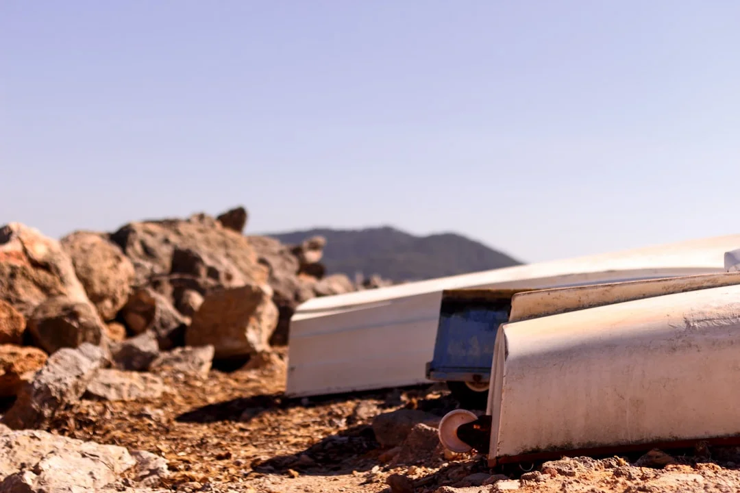 A leopard-spotted Neapolitan pizza sliding off a wooden peel into a glowing parabolic solar oven on a sun-drenched backyard patio, mountains visible in the background